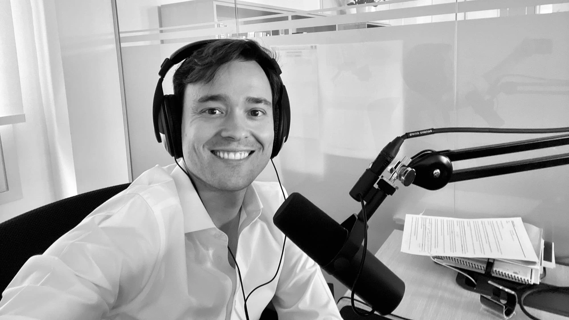 Armando Cuesta sonriendo ante el micrófono en un estudio de podcast